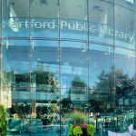 Image shows the glass exterior view of and entrance to the Hartford Public Library.